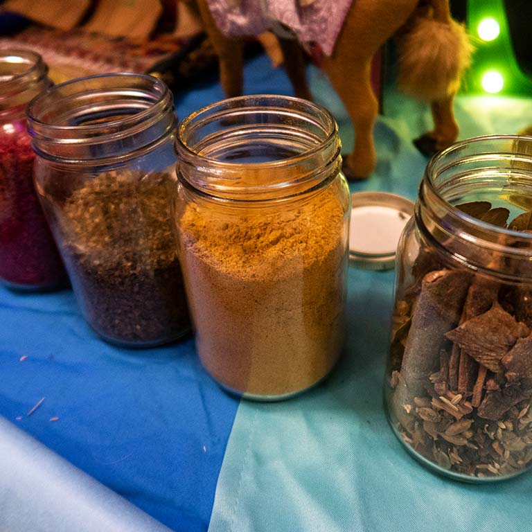 Four jars of spices sitting on a table.